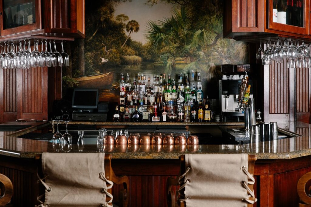 wooden hotel bar with leather chairs and florida mural at bohemian hotel celebration